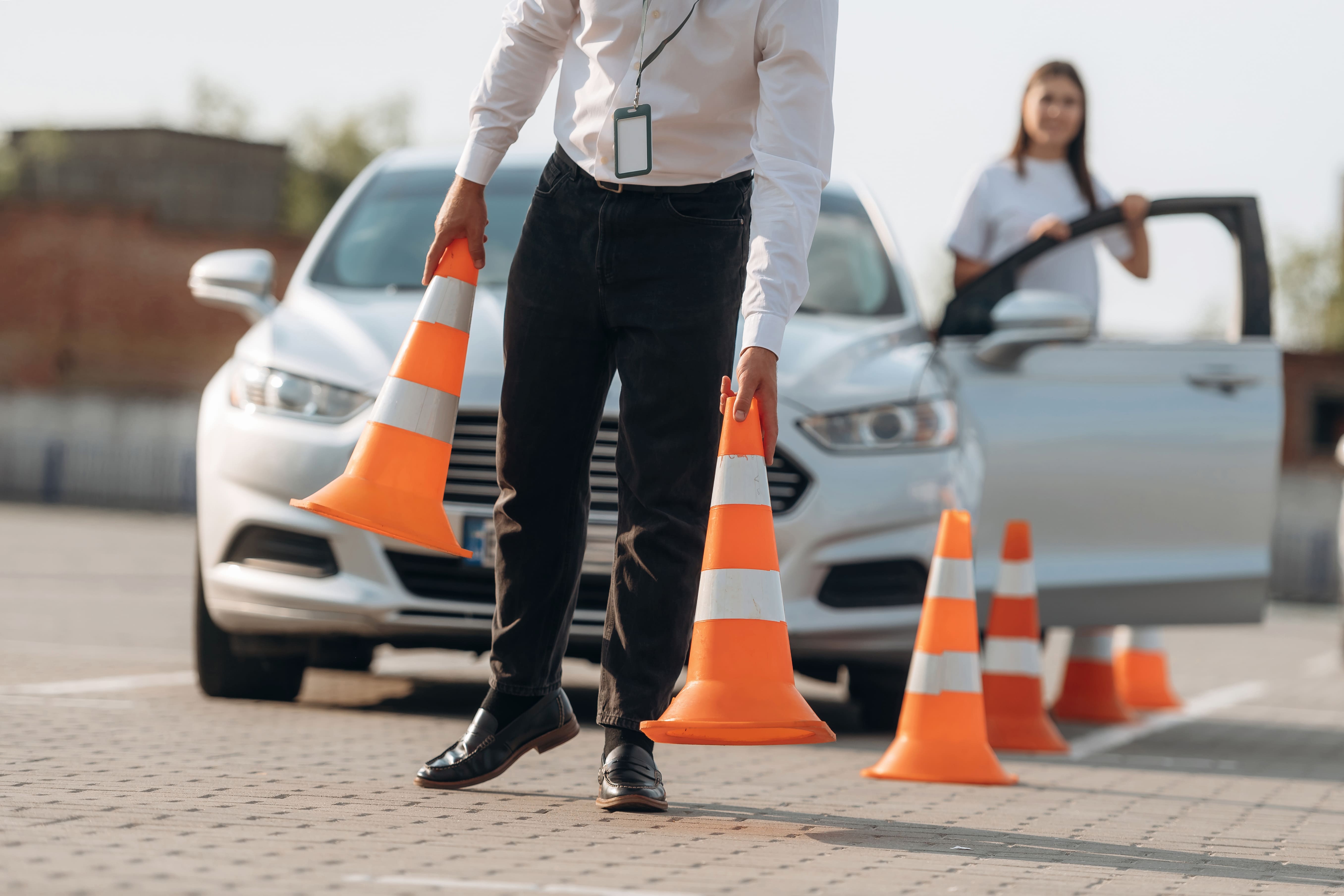 Instructor y alumno practicando maniobras en coche de autoescuela, examen práctico en circuito urbano de ciudad española
