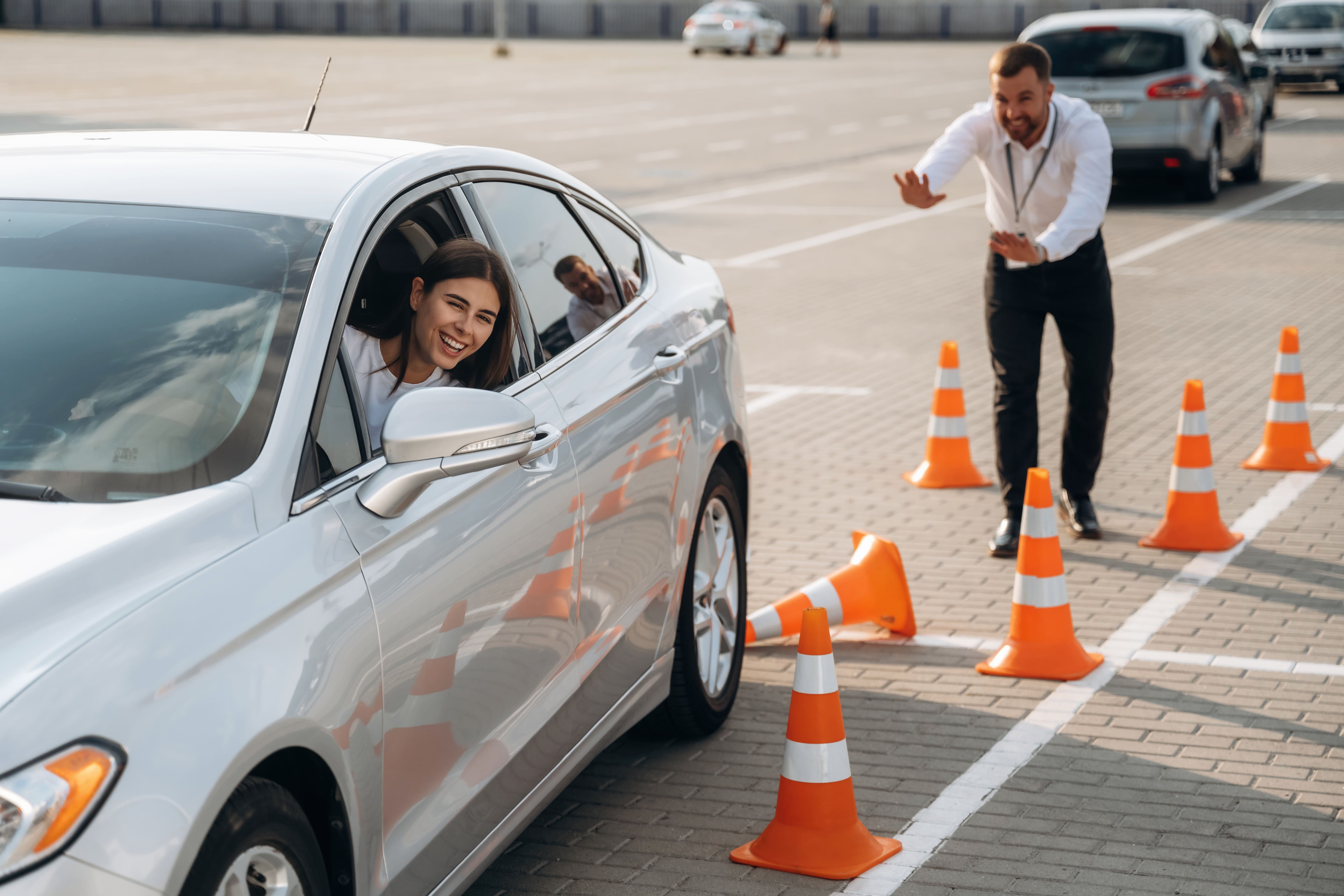 Coche de autoescuela circulando por carretera urbana, instructor y alumno practicando conducción segura en entorno real